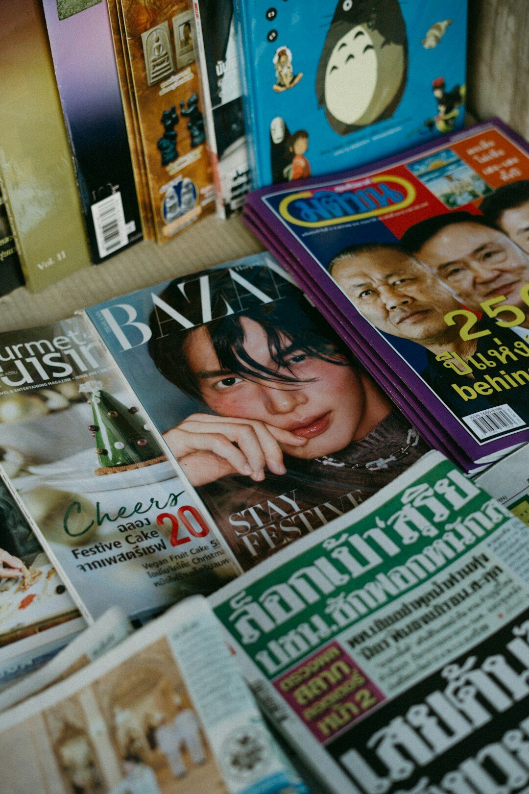 Neatly arranged stack of glossy magazines with reading glasses