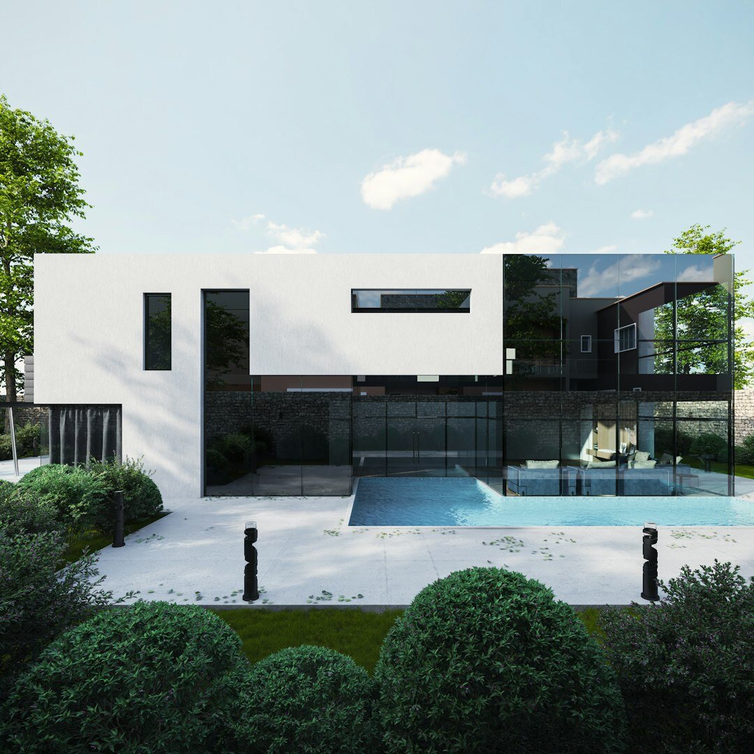 Modernist villa exterior with glass facades surrounded by greenery