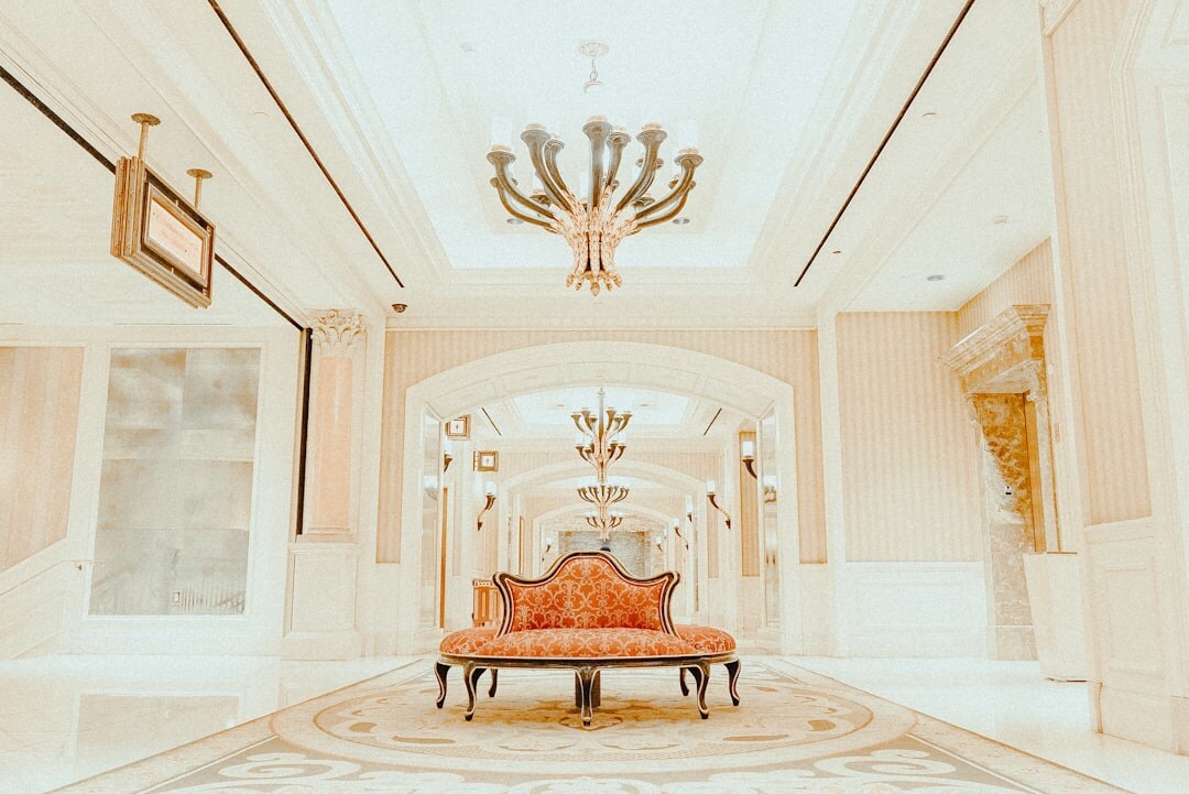 Grand villa foyer with a curved marble staircase and chandelier